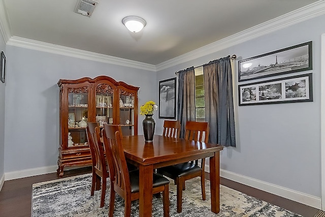 dining room featuring dark wood-type flooring and ornamental molding