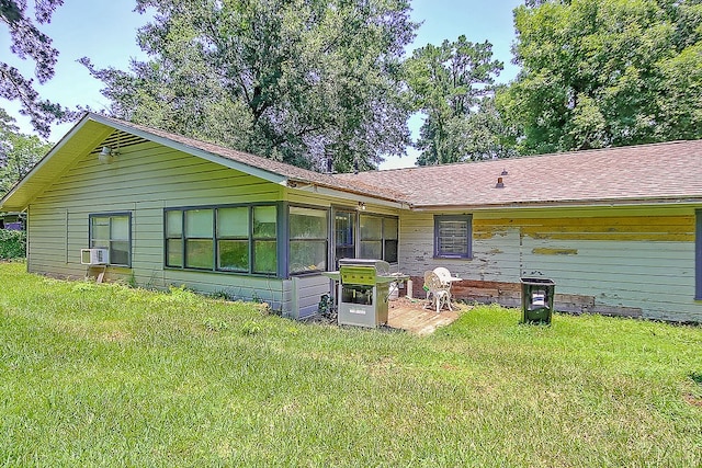 rear view of house with a lawn and cooling unit