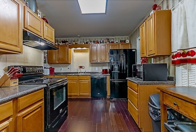 kitchen featuring black appliances, dark hardwood / wood-style floors, and sink