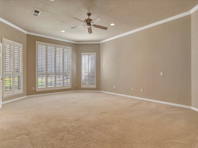 unfurnished room featuring a wealth of natural light, baseboards, visible vents, ceiling fan, and crown molding