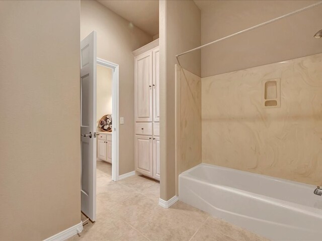 bathroom with baseboards, tile patterned flooring, a bathtub, and a shower