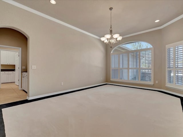 empty room featuring recessed lighting, ornamental molding, arched walkways, baseboards, and a notable chandelier