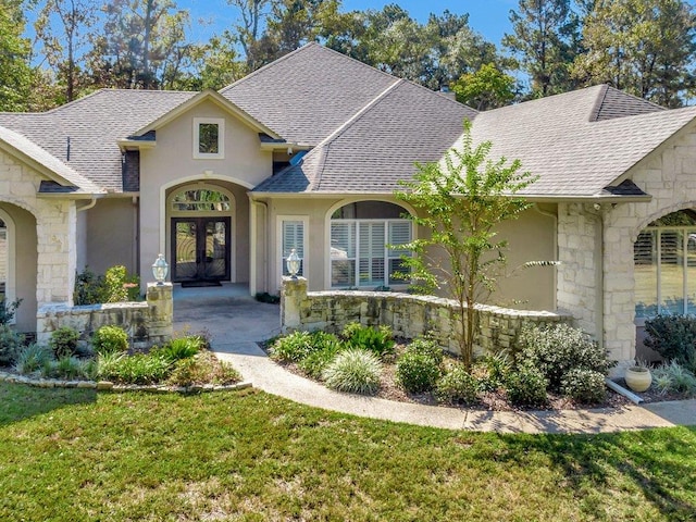 view of front of house with stone siding, a shingled roof, and french doors