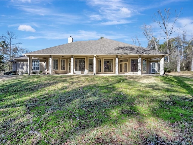rear view of property with a ceiling fan, a lawn, a chimney, and roof with shingles