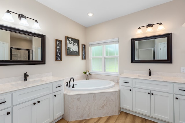 211 Rustic Pines Dr, Lufkin, TX 75904 - full bathroom featuring two vanities, wood finished floors, a bath, and a shower with door