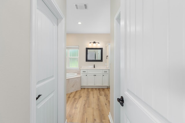 211 Rustic Pines Dr, Lufkin, TX 75904 - bathroom featuring vanity, wood finished floors, a bath, and recessed lighting