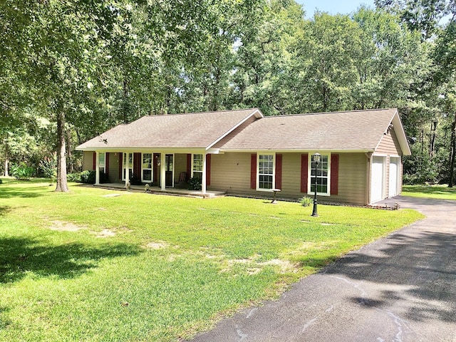 single story home featuring a garage, a front yard, and covered porch