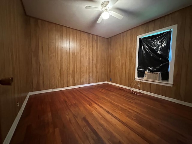 113 Butler St, Lufkin, TX 75904 - spare room featuring a ceiling fan, wood finished floors, cooling unit, and wooden walls