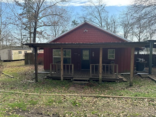 exterior space with an outbuilding, a porch, fence, a storage unit, and board and batten siding