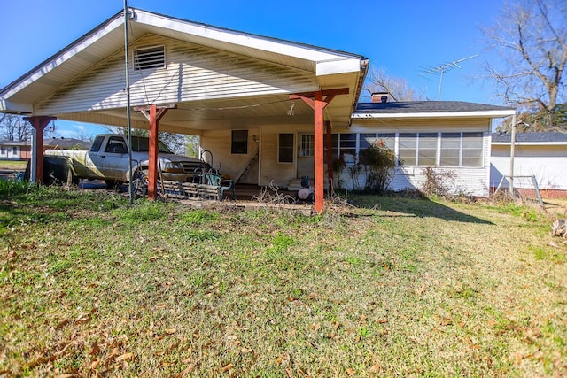 rear view of house with a carport and a lawn