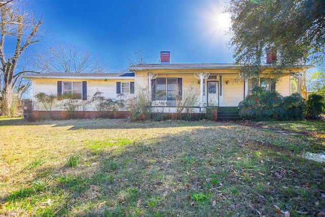 ranch-style home with a porch, a front yard, and a chimney