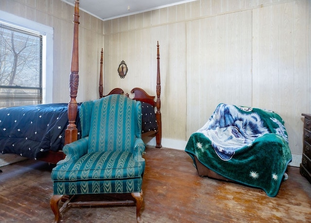 living area with crown molding, wood walls, and wood finished floors