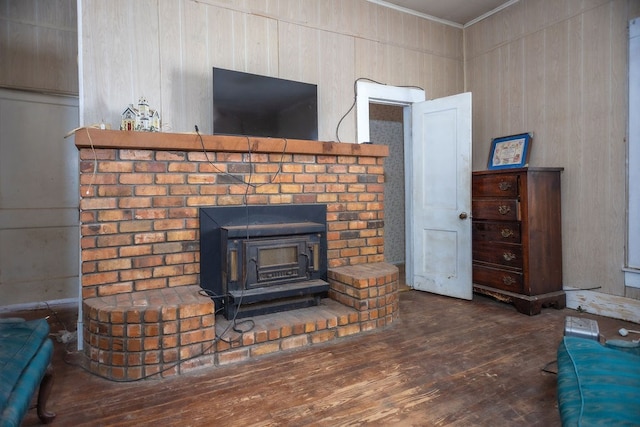 details with a wood stove, ornamental molding, and wood finished floors