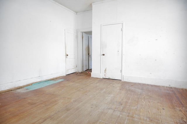 unfurnished room featuring ornamental molding and wood finished floors