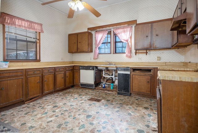 kitchen featuring brown cabinets, ornamental molding, white dishwasher, ceiling fan, and wallpapered walls