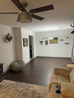living room with a wood stove and ceiling fan