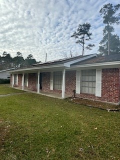 exterior space featuring a front lawn and brick siding
