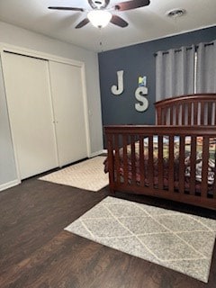 bedroom featuring a ceiling fan, wood finished floors, a closet, baseboards, and visible vents