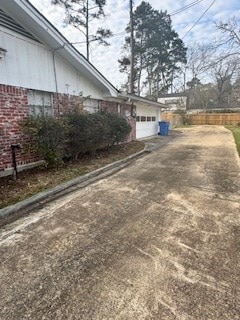 view of home's exterior featuring a garage, driveway, and brick siding