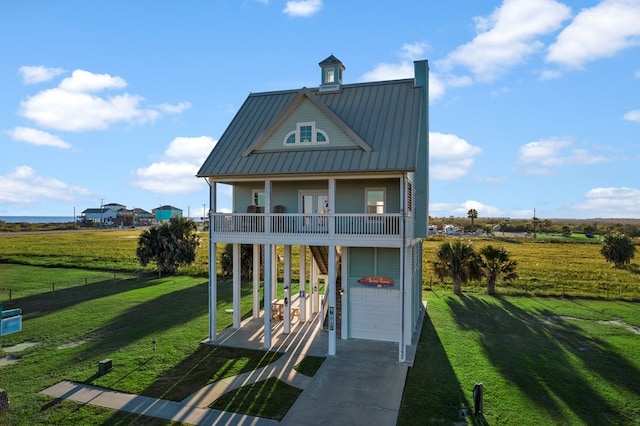 view of front of property featuring covered porch, a garage, a balcony, and a front yard