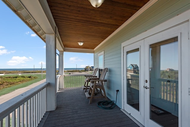 wooden terrace with french doors and a water view