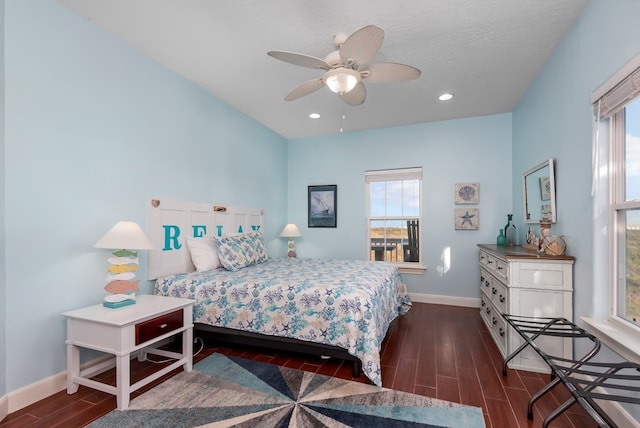 bedroom with multiple windows, ceiling fan, dark hardwood / wood-style flooring, and a textured ceiling