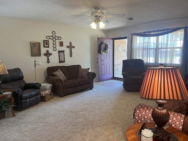 living room with a textured ceiling, light colored carpet, and ceiling fan