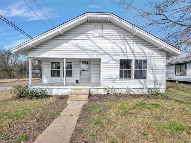 bungalow-style home with a front yard and covered porch