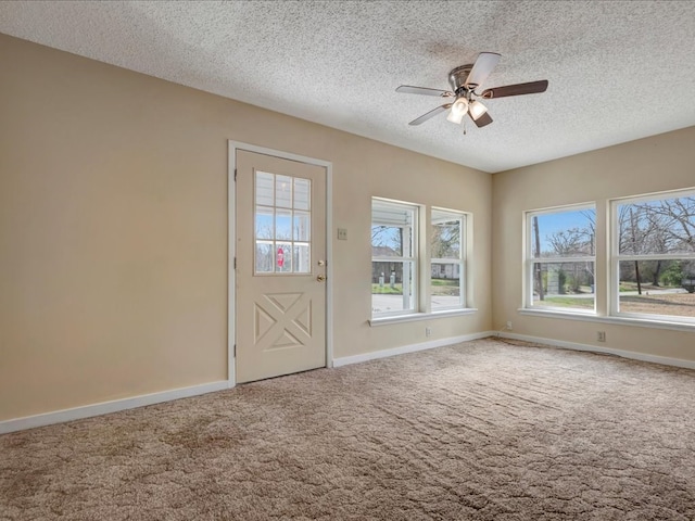 carpeted entrance foyer with ceiling fan and a textured ceiling