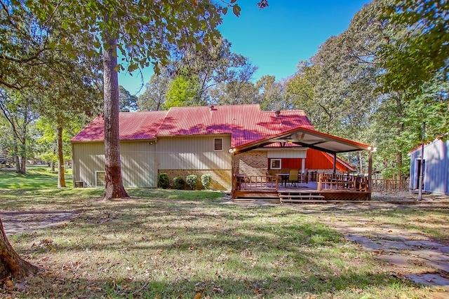 rear view of house with a tile roof, a deck, and a lawn