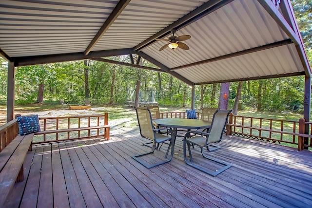 wooden deck featuring outdoor dining area and a ceiling fan