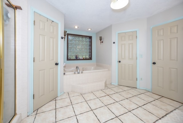 full bathroom with a textured ceiling, tile patterned flooring, and a garden tub