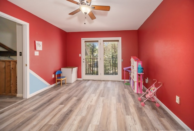 recreation room featuring light wood-type flooring, ceiling fan, and baseboards