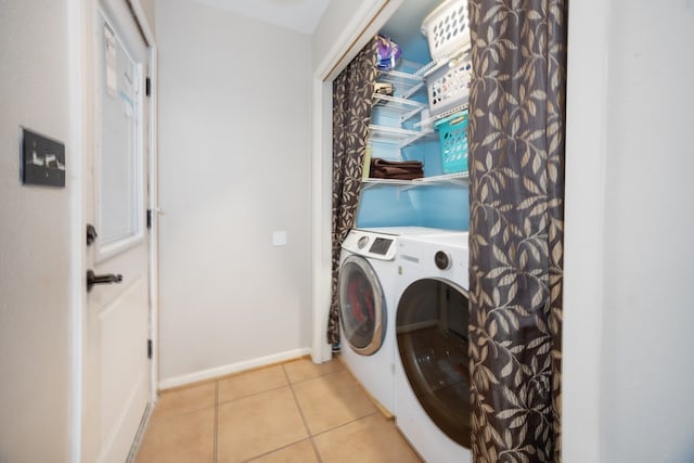 laundry room with laundry area, light tile patterned floors, baseboards, and separate washer and dryer