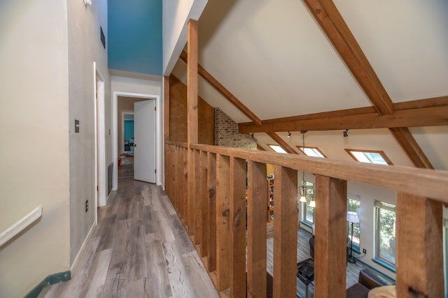 hallway with vaulted ceiling with beams and wood finished floors