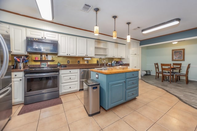 kitchen with visible vents, white cabinets, butcher block countertops, stainless steel appliances, and pendant lighting