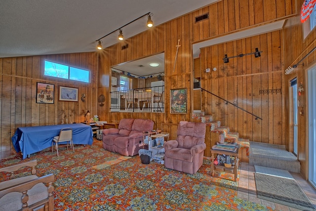210 Cedar Rdg, Hemphill, TX 75948 - living room with wooden walls, visible vents, stairway, lofted ceiling, and carpet flooring