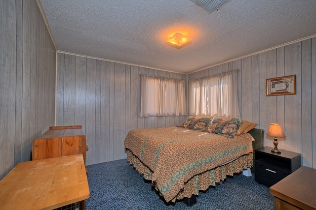 210 Cedar Rdg, Hemphill, TX 75948 - bedroom with visible vents, a textured ceiling, wood walls, and carpet flooring