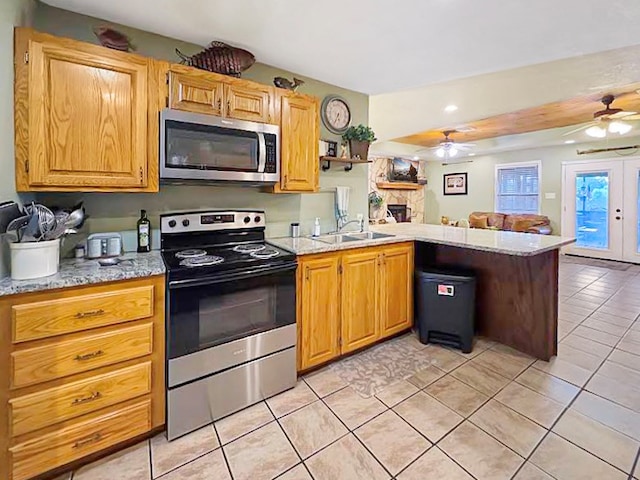 341 Red Wolf Ln, Brookeland, TX 75931 - kitchen featuring appliances with stainless steel finishes, a peninsula, ceiling fan, light tile patterned floors, and open floor plan