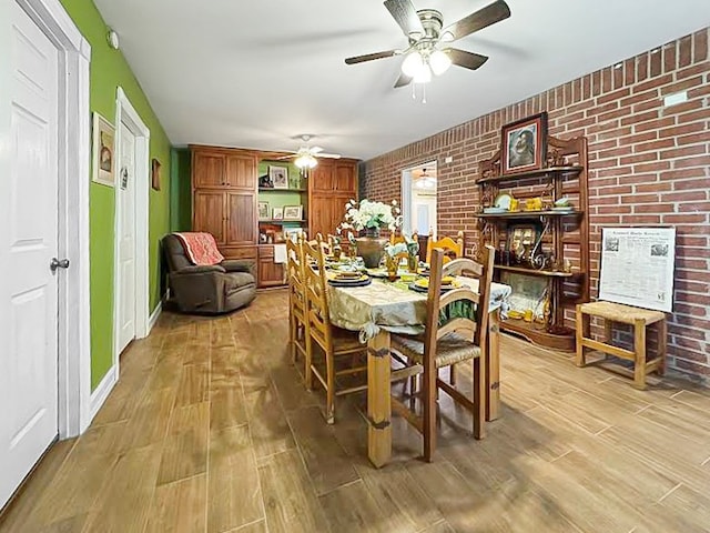 341 Red Wolf Ln, Brookeland, TX 75931 - dining room with brick wall, ceiling fan, and light wood-type flooring