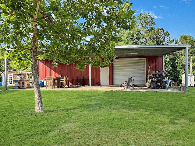 341 Red Wolf Ln, Brookeland, TX 75931 - view of green lawn featuring a garage and an outbuilding