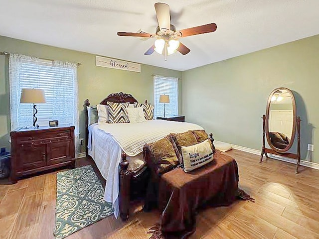 341 Red Wolf Ln, Brookeland, TX 75931 - bedroom featuring light wood finished floors, multiple windows, and a ceiling fan