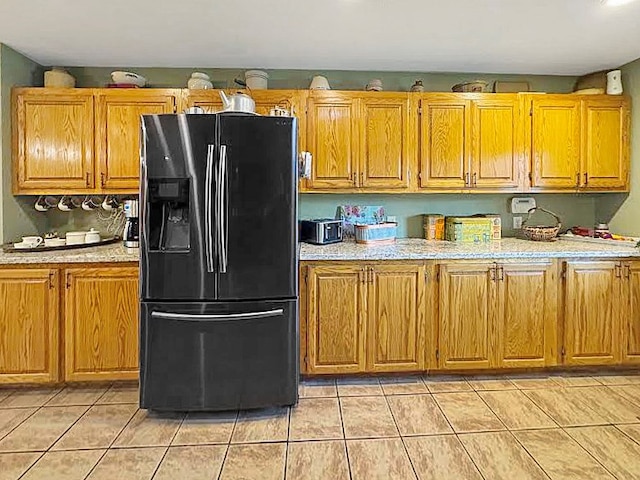341 Red Wolf Ln, Brookeland, TX 75931 - kitchen with fridge with ice dispenser, light countertops, light tile patterned floors, and brown cabinets