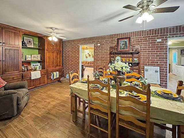 341 Red Wolf Ln, Brookeland, TX 75931 - dining area featuring a ceiling fan, brick wall, and wood finished floors