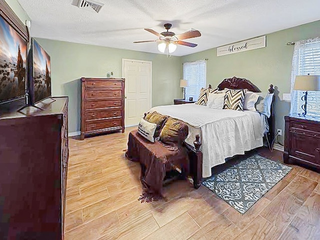 341 Red Wolf Ln, Brookeland, TX 75931 - bedroom featuring light wood finished floors, ceiling fan, and a textured ceiling