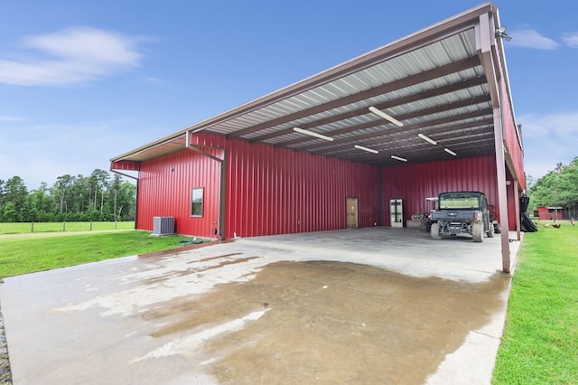 garage with central air condition unit and a lawn