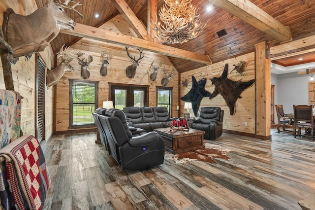 living room with hardwood / wood-style floors, vaulted ceiling with beams, wooden ceiling, and wood walls