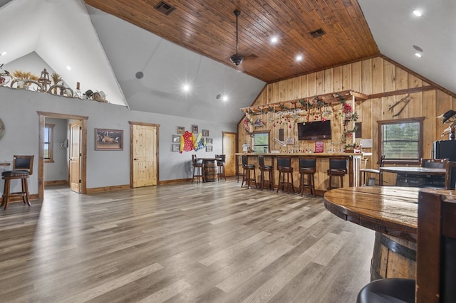 interior space with ceiling fan, wood-type flooring, high vaulted ceiling, wooden ceiling, and wood walls