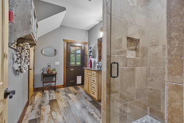 bathroom featuring hardwood / wood-style floors, vanity, an enclosed shower, and lofted ceiling