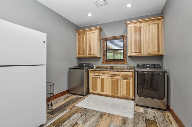 laundry room featuring dark hardwood / wood-style floors, cabinets, and separate washer and dryer